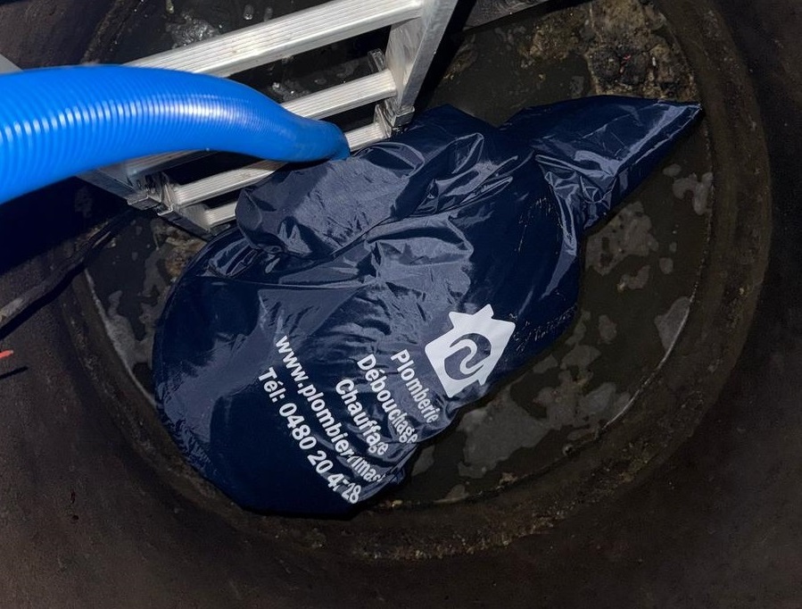 Technicien effectuant une vidange fosse septique Nivelles avec équipement spécialisé près d'une maison résidentielle