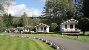 Rue pittoresque d'Amel avec maison en briques et enseigne Plombier Amel, cadre typique et chaleureux de la ville belge.