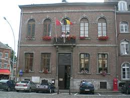 Plombier Beaumont devant l'église historique, entouré de vieilles maisons en pierre et rues pavées typiques de la ville.