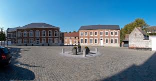 Vue sur une rue pittoresque de Beauvechain lors d'une intervention de débouchage avec architecture locale en arrière-plan