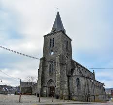 Plombier Bièvre devant une église historique en pierre avec rues pavées et bâtiments anciens typiques de la région.