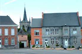 Rue pavée à Chièvres avec service de débouchage en action près de bâtiments historiques typiques du centre-ville.