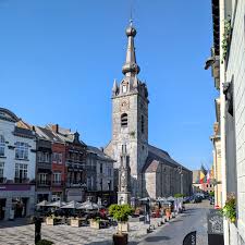 Plombier Chimay devant la Collégiale Saints-Pierre-et-Paul sous un ciel bleu typique de la ville de Chimay