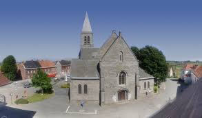 Plombier Estaimpuis : bâtiment en briques rouges typique avec rues pavées et enseigne artisanale locale en arrière-plan