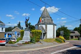 Camion de débouchage Lierneux stationné près de l'église Saint-André, architecture typique en pierre de la région