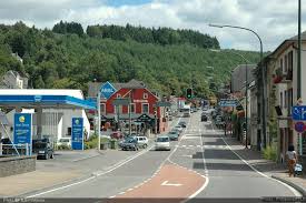 Vue pittoresque du centre de Martelange avec un spécialiste en débouchage de canalisations travaillant devant une maison en pierre