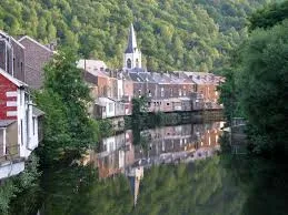 Plombier urgence Chaudfontaine, rue pittoresque avec maisons en briques et rivière traversant le centre apaisant de la ville