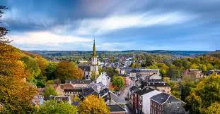 Plombier Eupen travaillant près de l'Hôtel de Ville d'Eupen, bâtiment historique avec son architecture typique en brique.