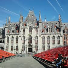 Plombier Evere devant l'église Saint-Vincent sur une rue animée avec boutiques et passants du quartier vivant.