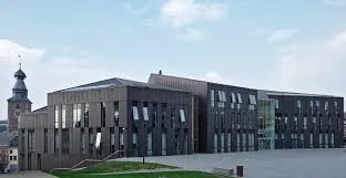 Scène urbaine de Gembloux avec spécialiste en débouchage devant l'hôtel de ville historique en brique et pierre. Débouchage Gembloux