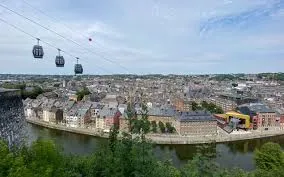 Un plombier à Namur avec la Citadelle en arrière-plan sous un ciel bleu, symbole emblématique de la ville charmante.
