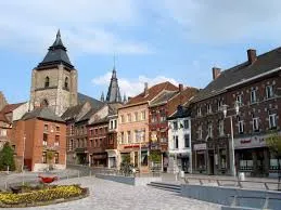 Rue animée de Soignies avec architecture traditionnelle, signalisation pour service de débouchage local, Débouchage Soignies